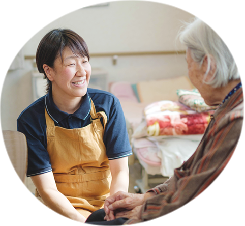 介護職員が入居者と親身に接する場面。日常的なケアとコミュニケーション。
